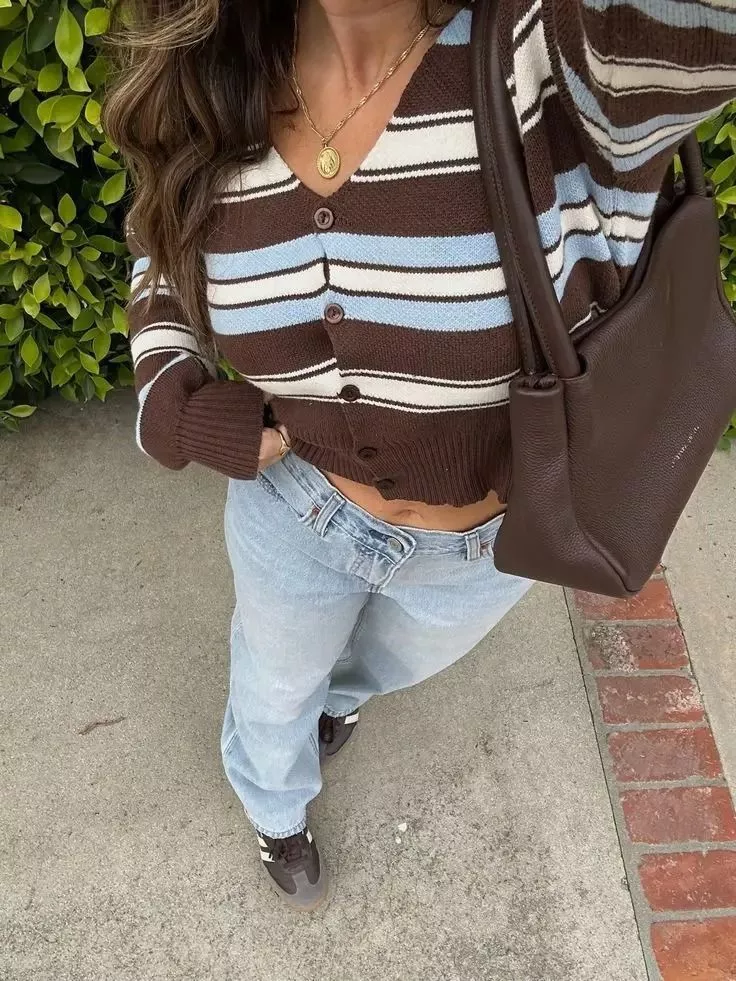 Donna indossa cardigan a righe marrone, azzurro e bianco con bottoni e jeans chiari, vista dall'alto