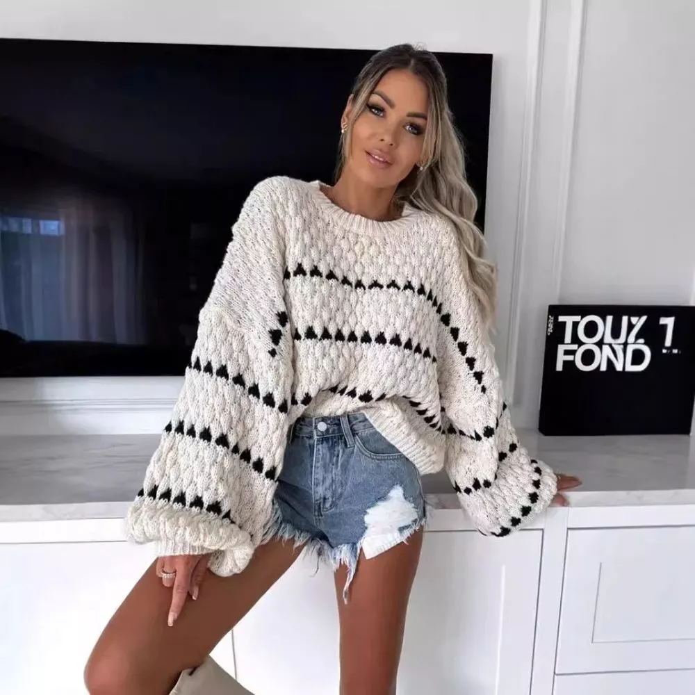 Modella con maglione bianco righe nere e pantaloni jeans